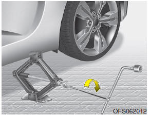 9. Insert the jack handle into the jack and turn it clockwise, raising the vehicle