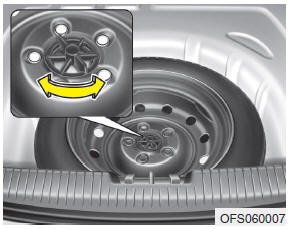 Turn the tire hold-down wing bolt counterclockwise.